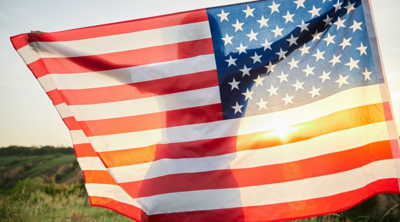 4th of July. American woman with the national American flag